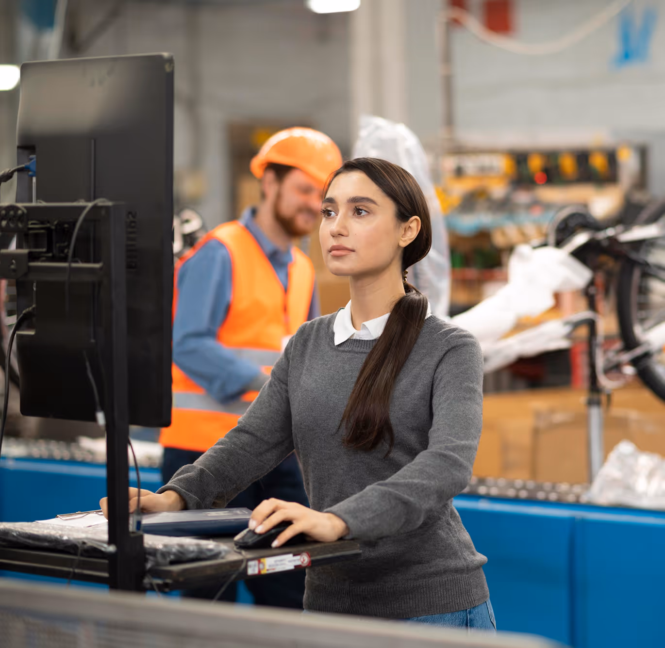 Two warehouse workers in safety gear reviewing a digital inspection checklist showing 100% score and 'Inspection passed' status.