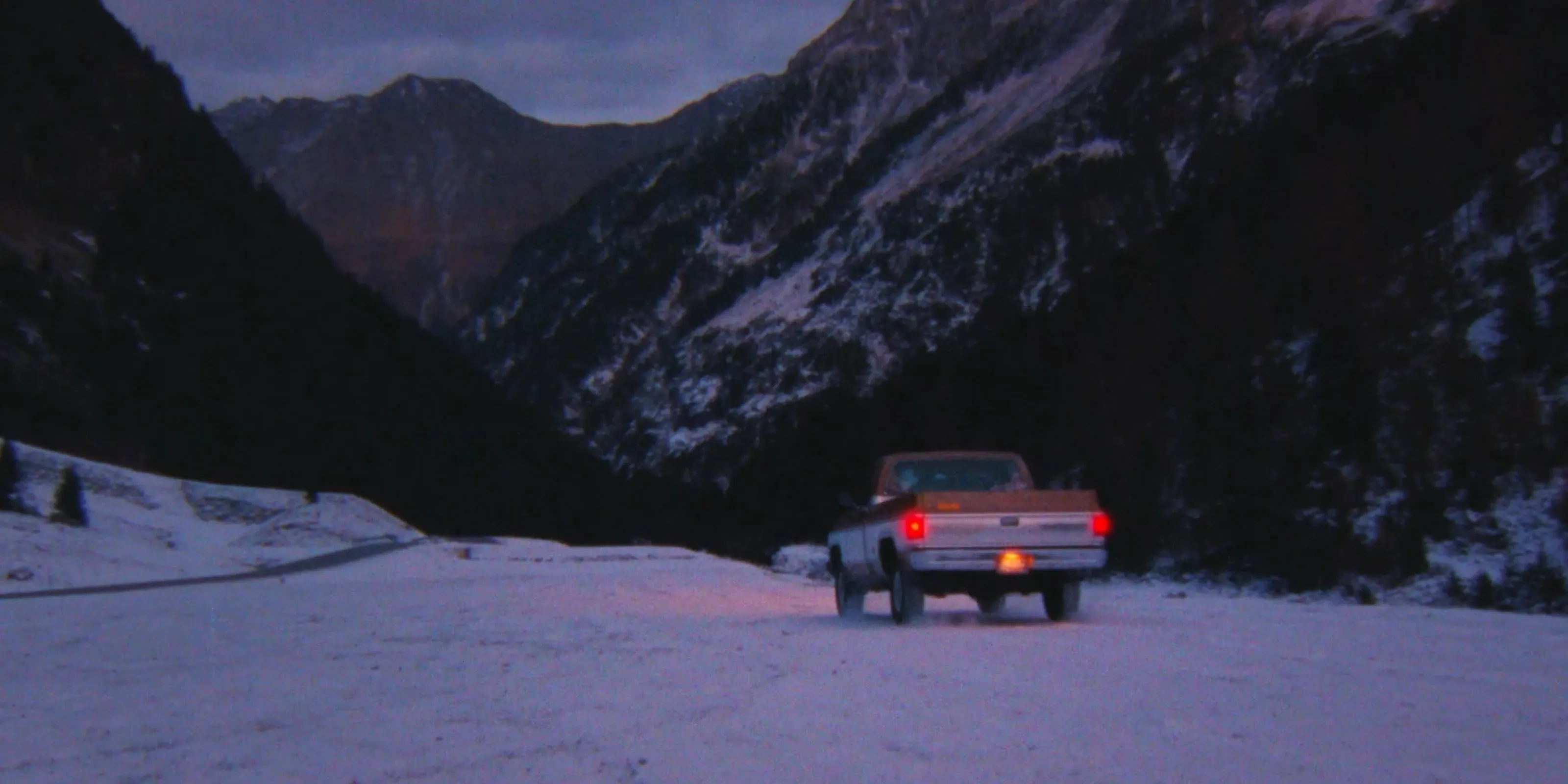 A vintage pickup truck driving through a snowy alpine valley at dusk — Floyd campaign film by CantSee.