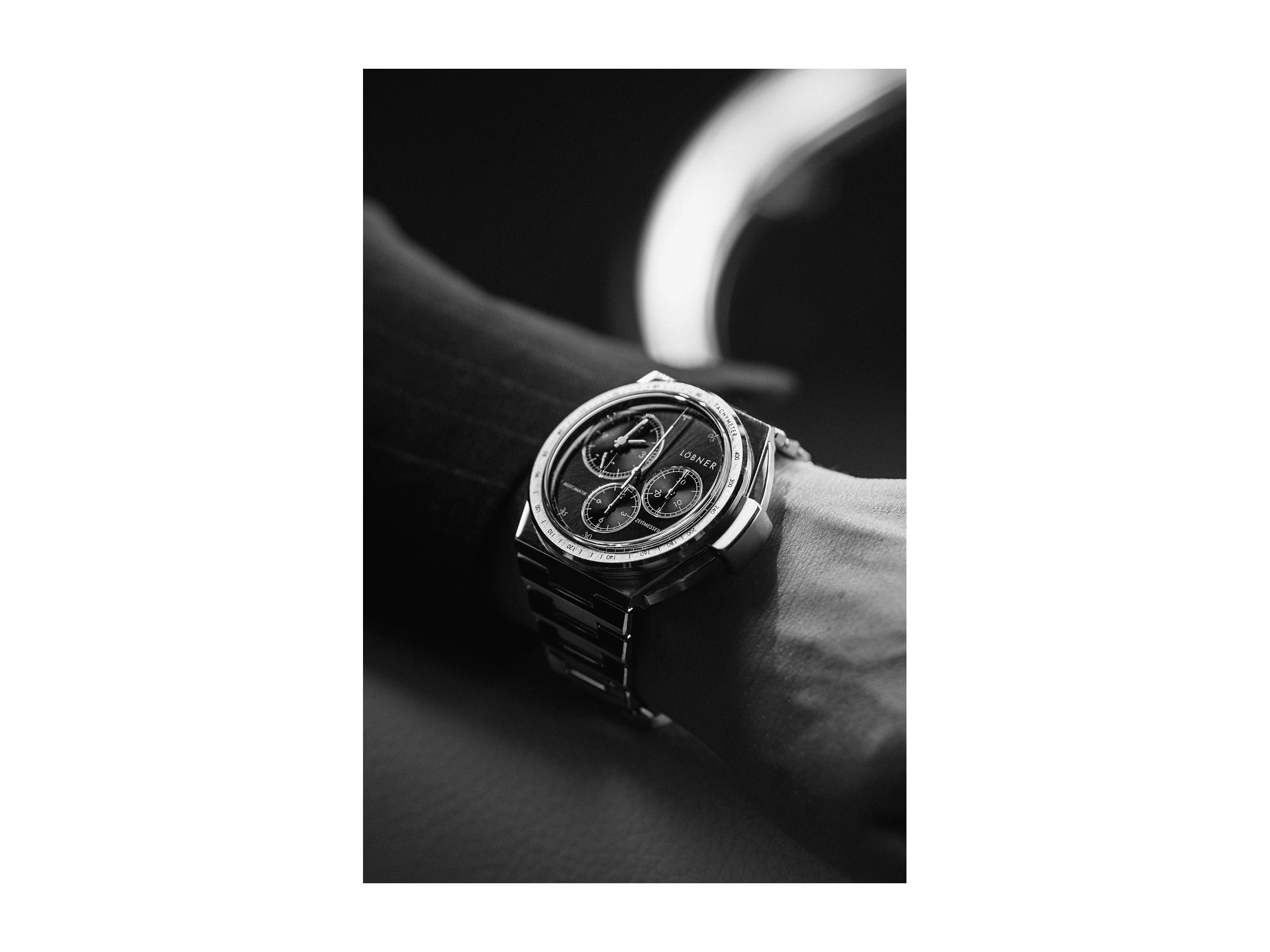 Close-up of the LÖBNER automatic chronograph on a wrist, black dial and steel bracelet, directed and produced by Studio ONOM