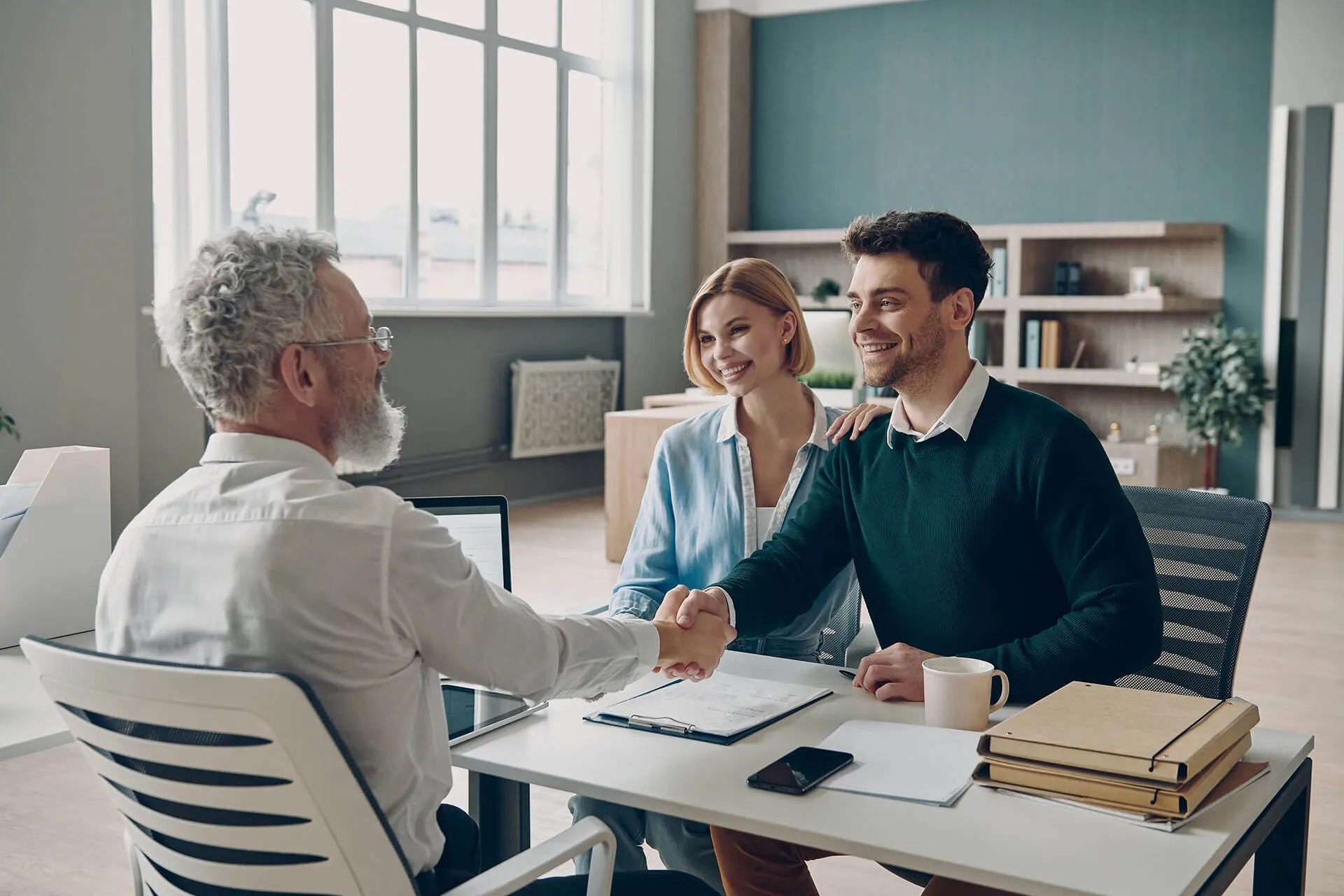 Couple shaking hands with financial advisor