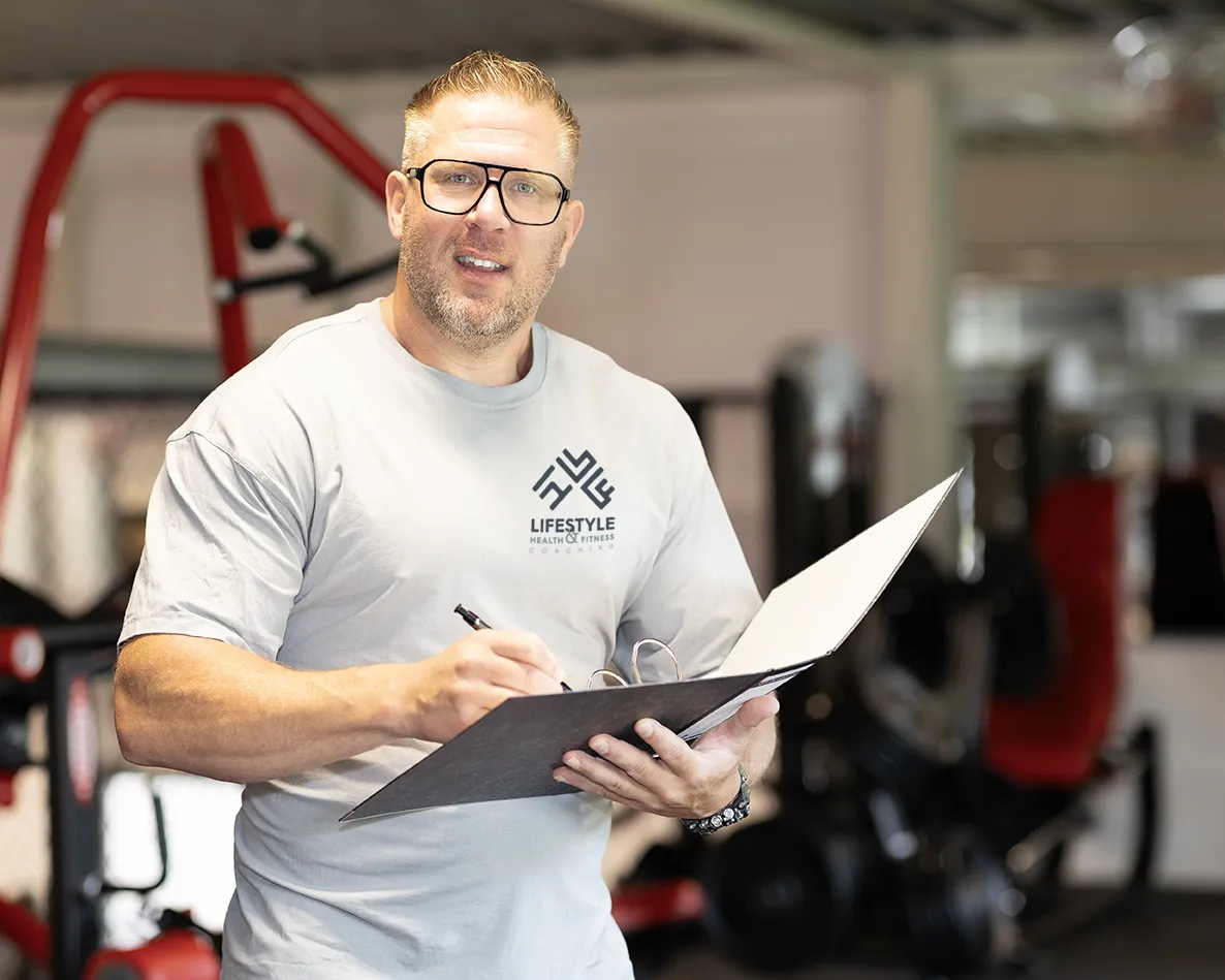 Benjamin lachend naar de camera met een map in zijn handen