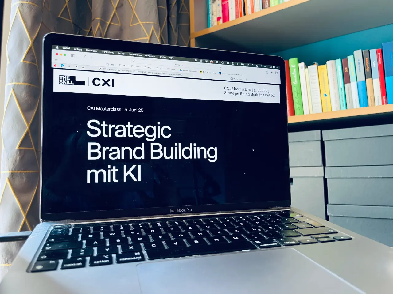MacBook Pro zeigt CXI Masterclass-Website 'Strategic Brand Building mit KI' vor Bücherregal