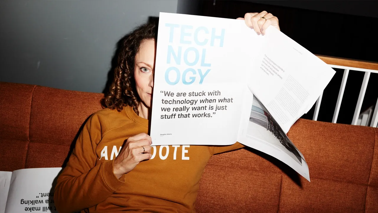 Frau liest Technologie-Magazin mit Zitat über praktische vs. komplexe Technologie