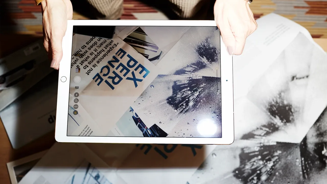 Tablet-Kamera fotografiert Arbeitsdokumente mit 'EXPERIENCE' Schriftzug