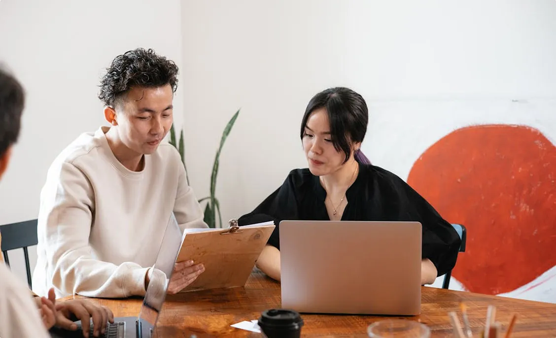 Deux professionnels travaillants l'un à côté de l'autre sur leurs ordinateurs portables