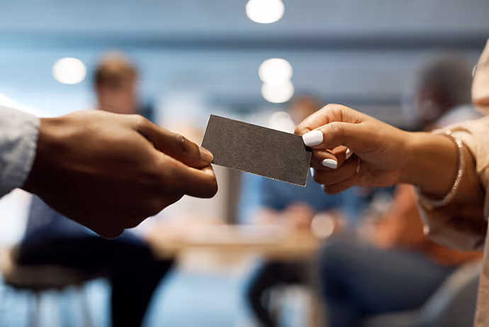 A woman hands a man a card