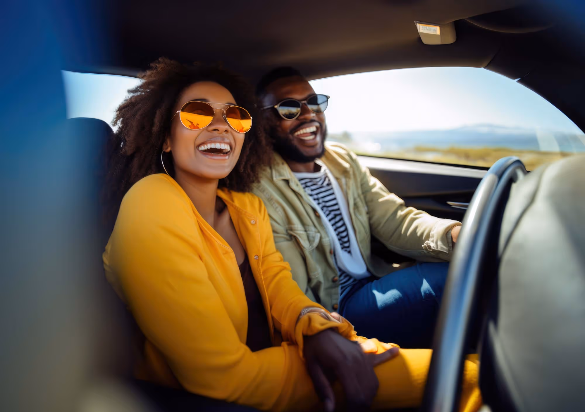 A couple smilies as they drive their car.