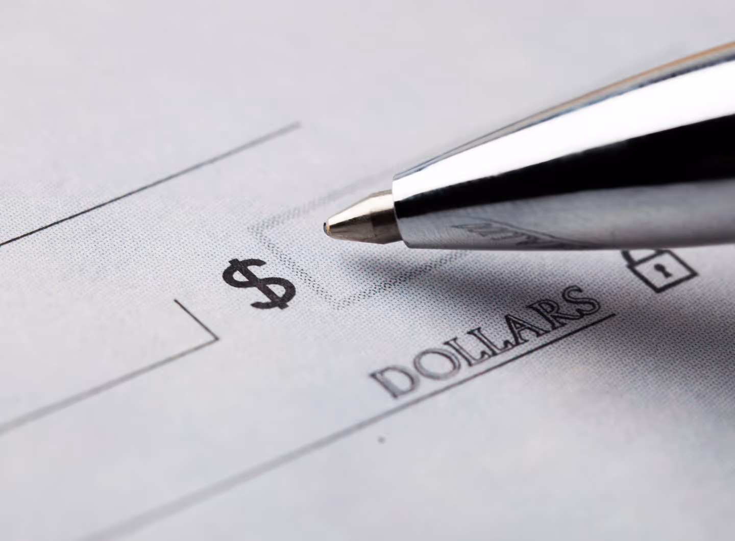 A pen hovers over a blank check