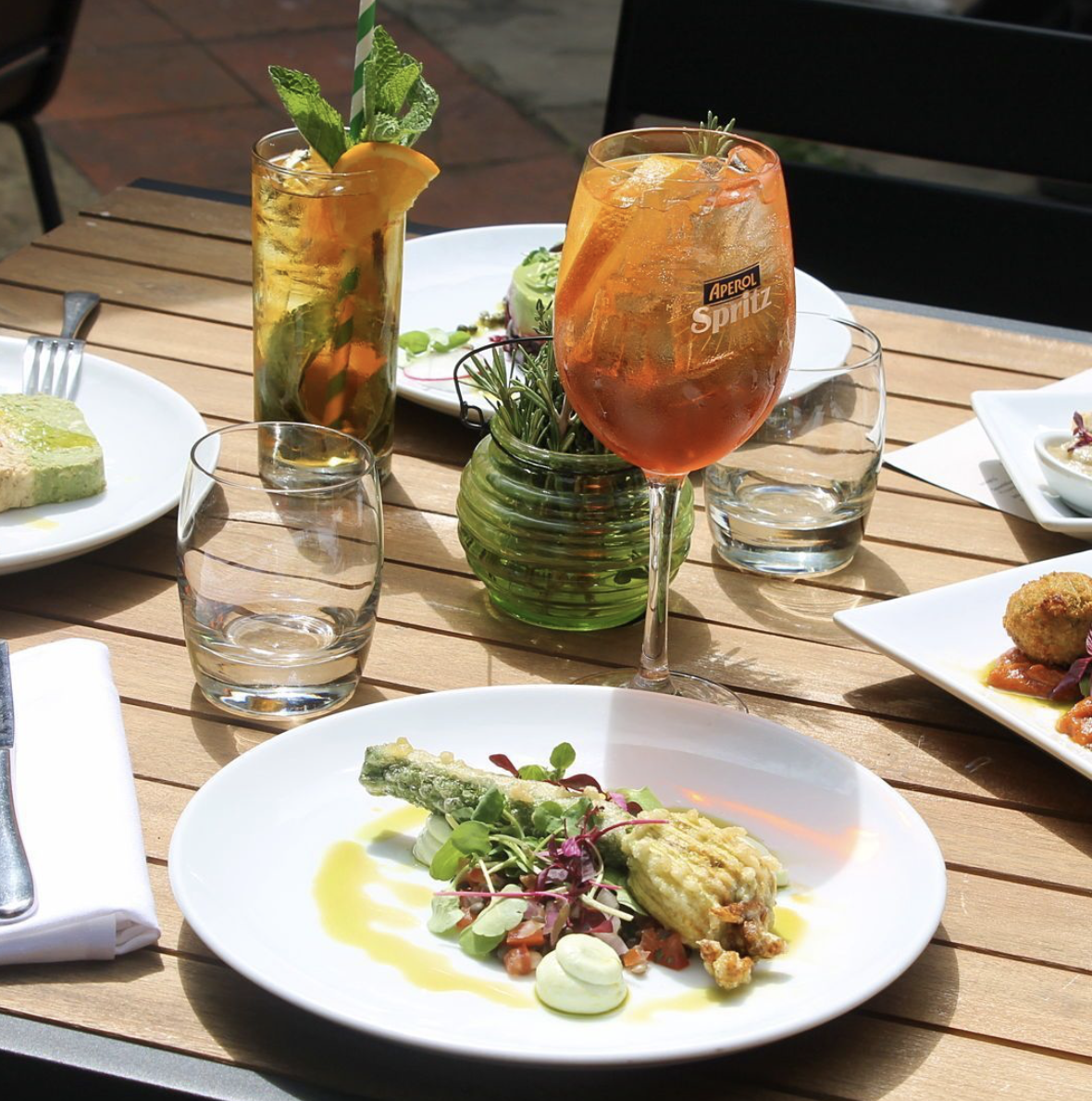 A photo of the vegan main course; Crispy Courgette Flower filled with butternut squash, sun dried tomatoes pine nuts & basil, served with buckwheat & tomato salad, truffle aioli