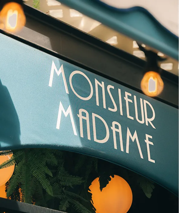 Enseigne de Monsieur Madame sous la marquise à rayures