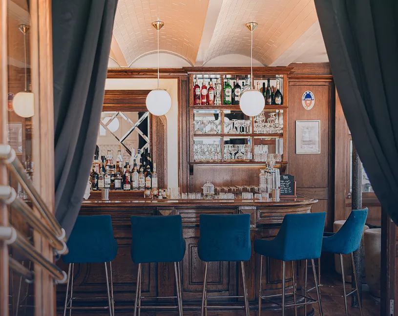 Bar élégant avec tabourets bleus et rideaux de velours