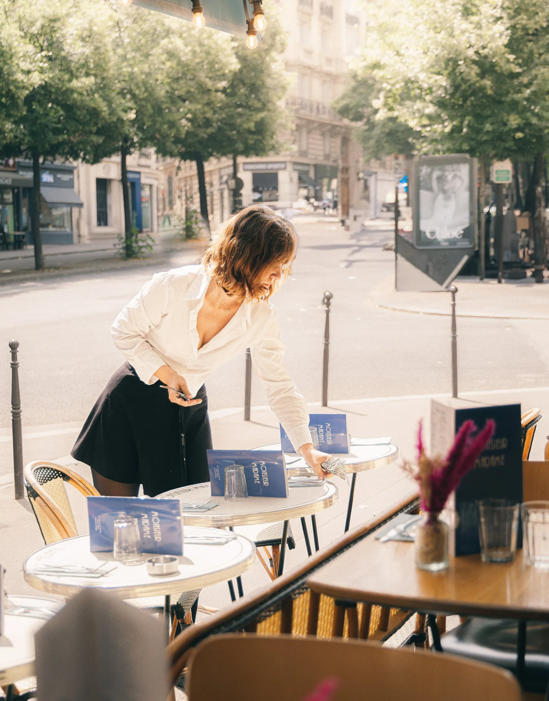 Serveuse dressant une table en terrasse
