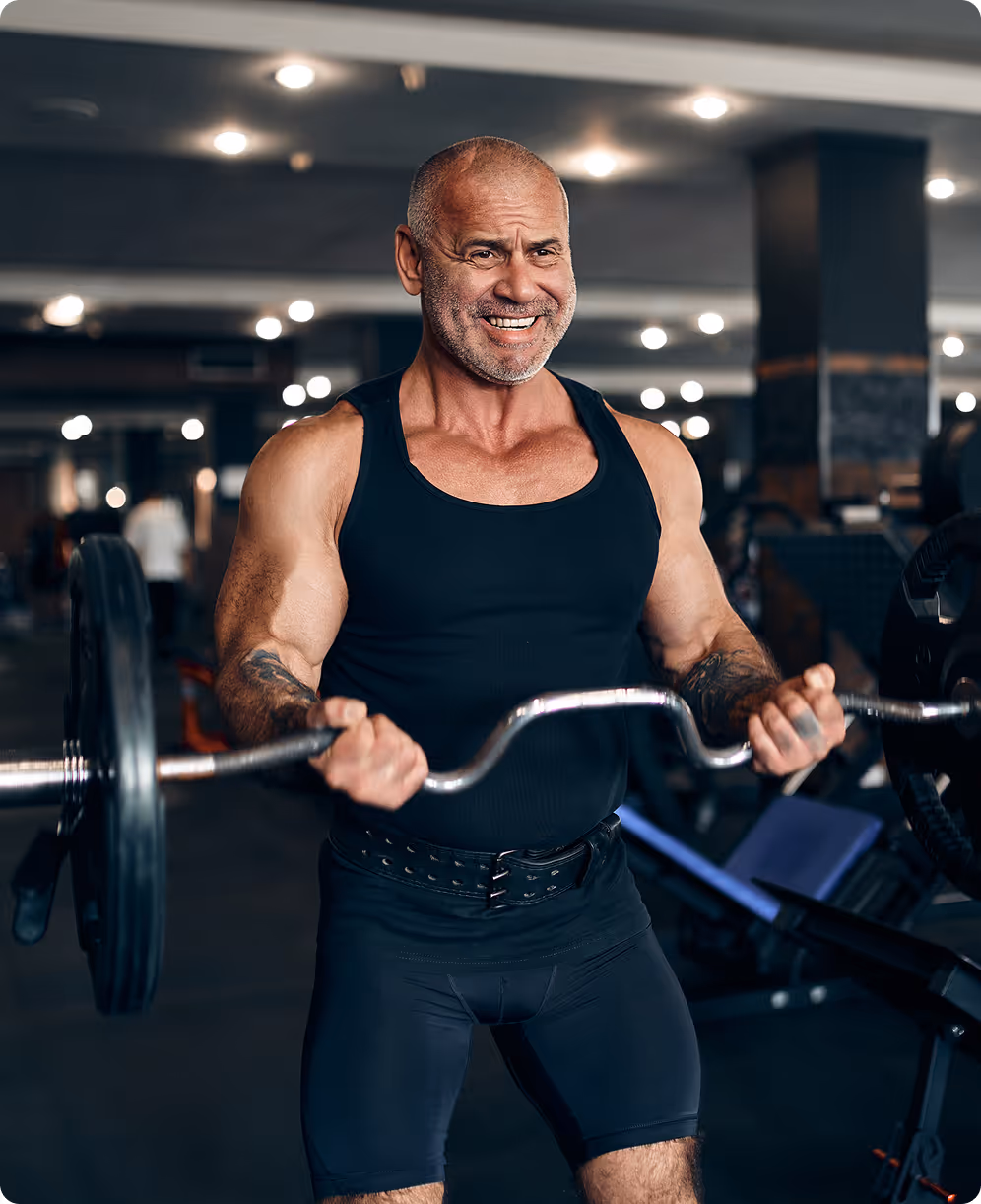 A man with a barbell in a gym.