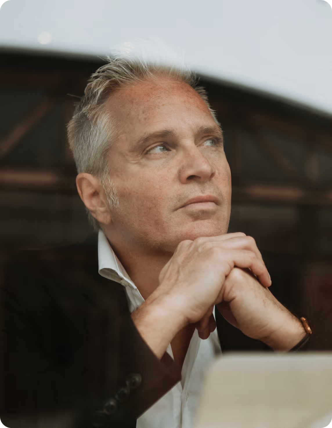 A man in a suit and tie looking out a window.