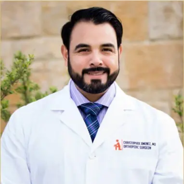 A man with a beard wearing a lab coat.