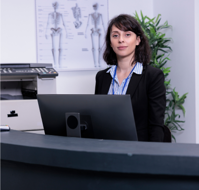 A woman sitting at a desk with a laptop.