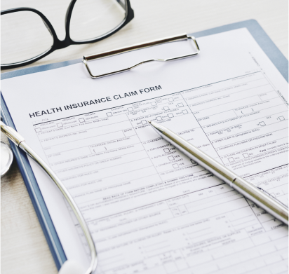 A clipboard with a health insurance claim next to a pair of eyeglasses.