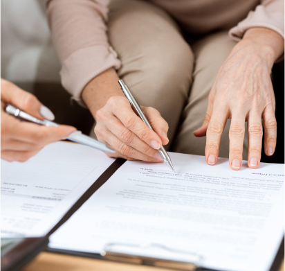 Two people sitting at a table with a pen and paper.