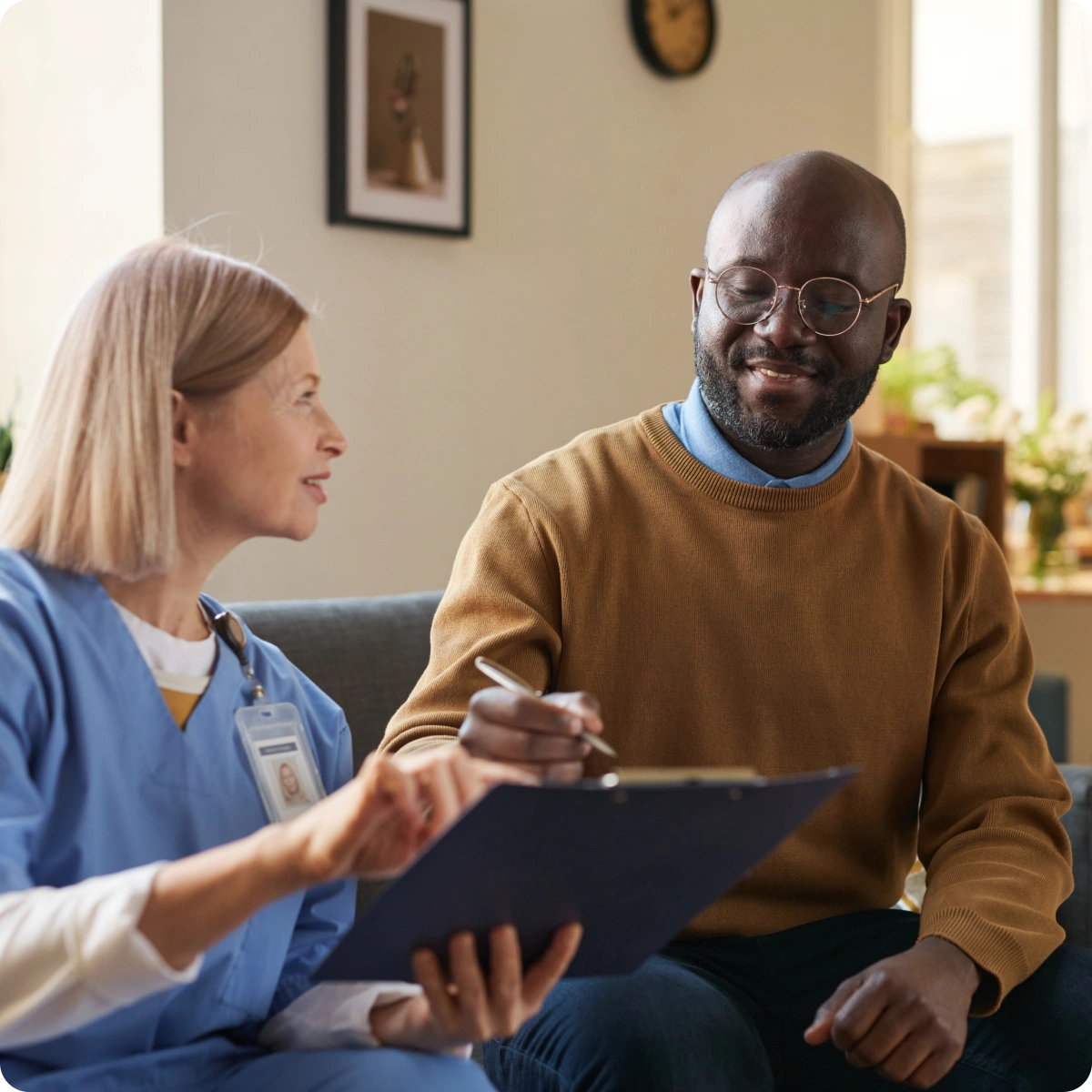 A man and woman sitting on a couch talking to each other.