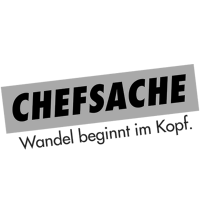 Logo mit dem Text 'Chefsache' in fetter Schrift auf grauem Hintergrund und dem Slogan 'Wandel beginnt im Kopf' darunter.