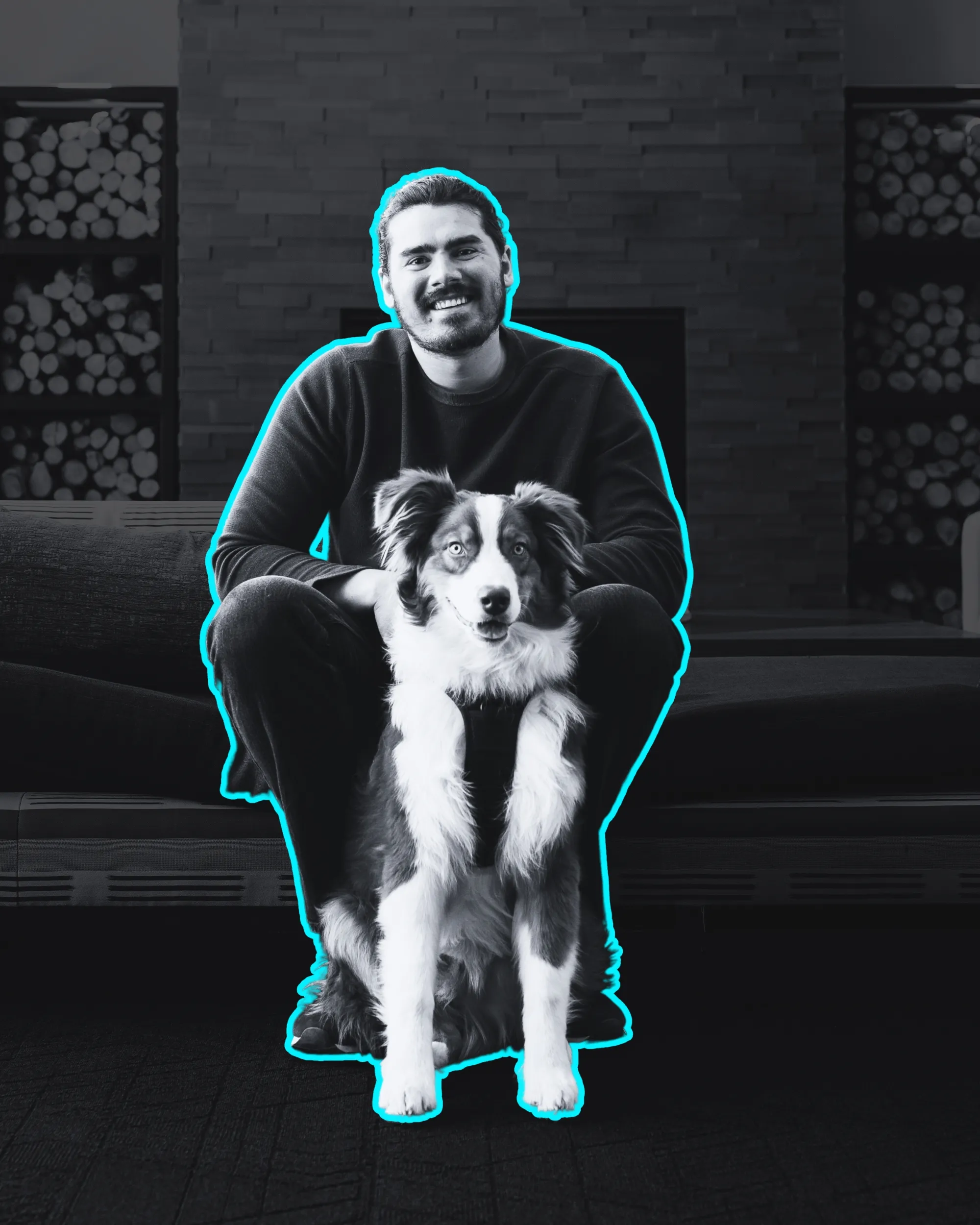 Taylor Scher, a young professional with dark hair sitting with his Aussie Shepherd.