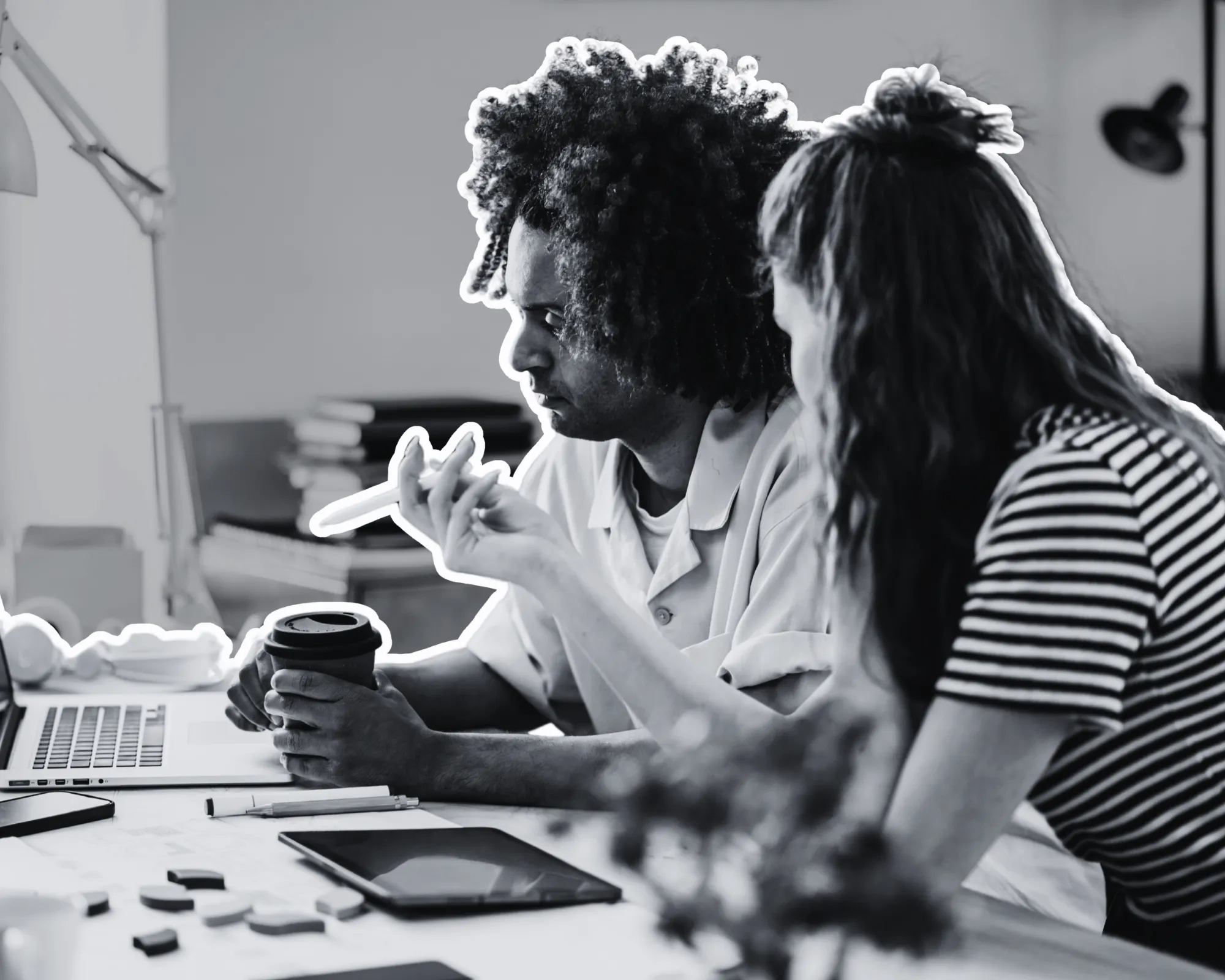Two young professionals working together with a laptop and tablet.