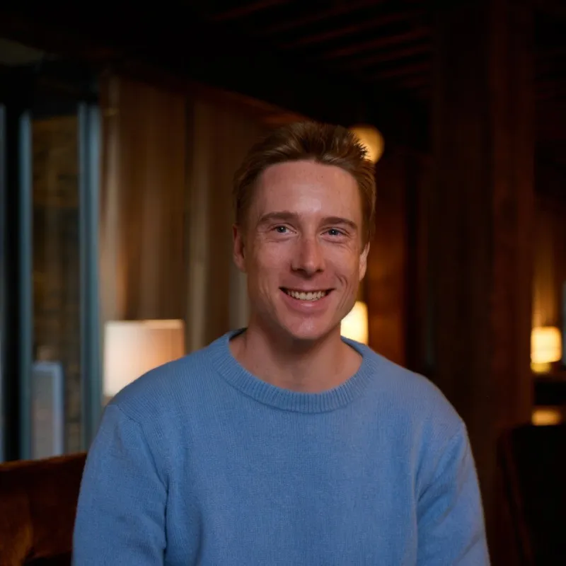 A man with blond hair smiles at a camera.