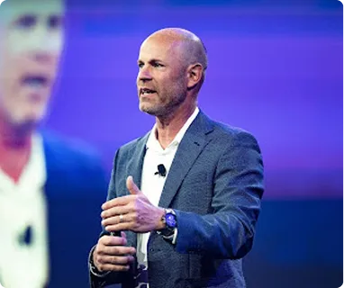 Speaker in blue blazer presenting with revLogic passion on stage
