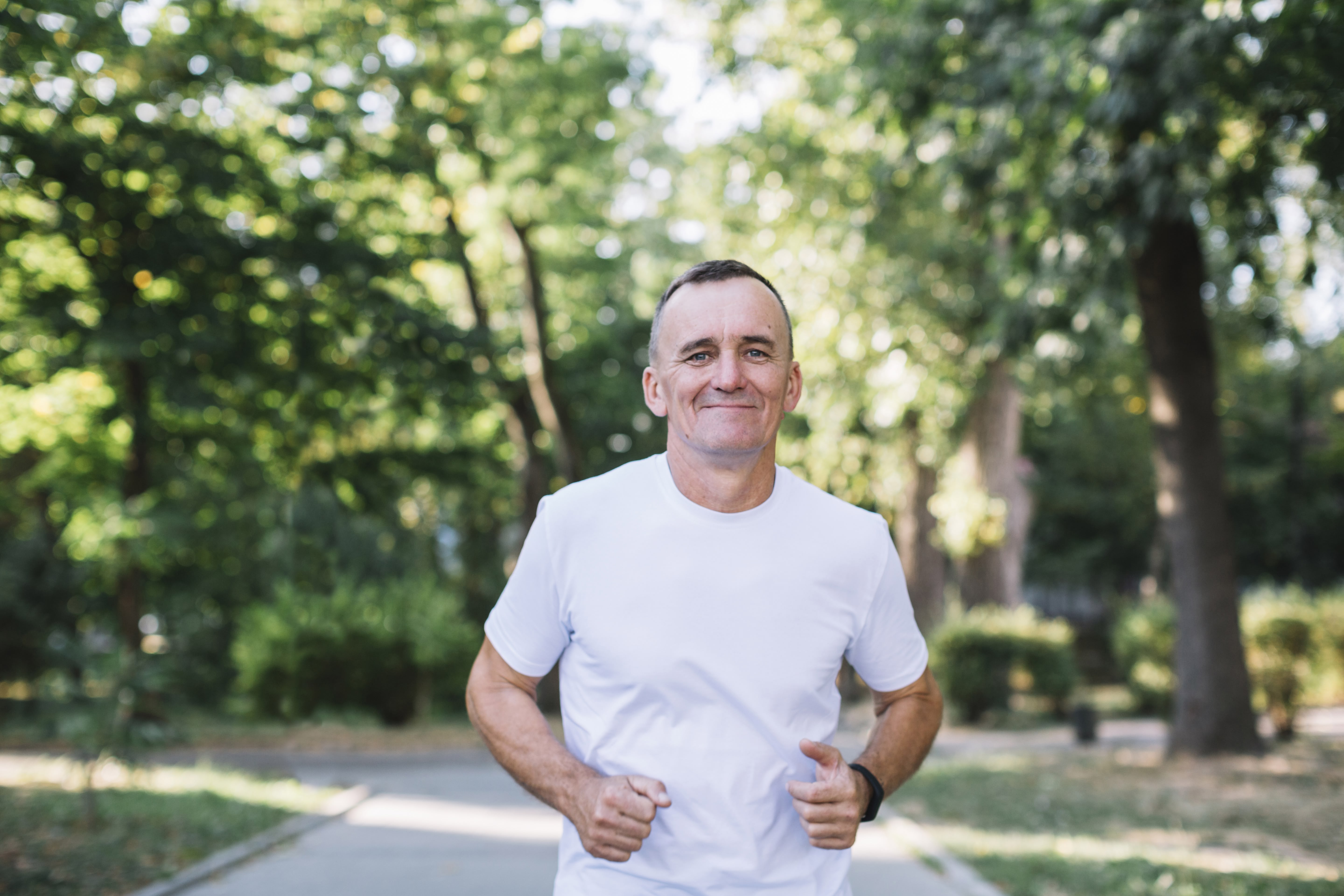 Un homme de 50 ans souriant pendant une marche active au parc