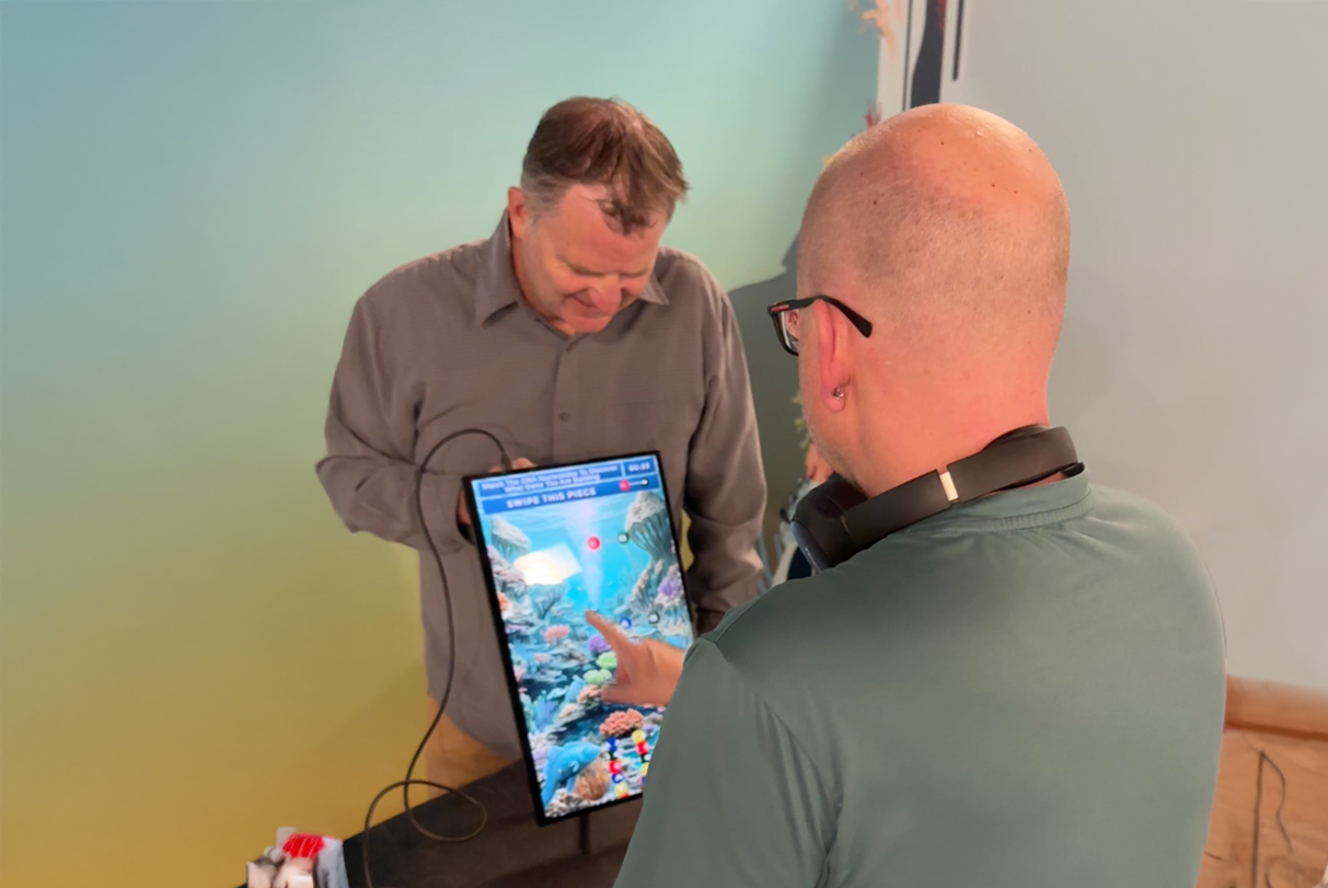 Custom-built touchscreen kiosk at Butterfly Pavilion running the Unity-developed DNA and genetics educational game.