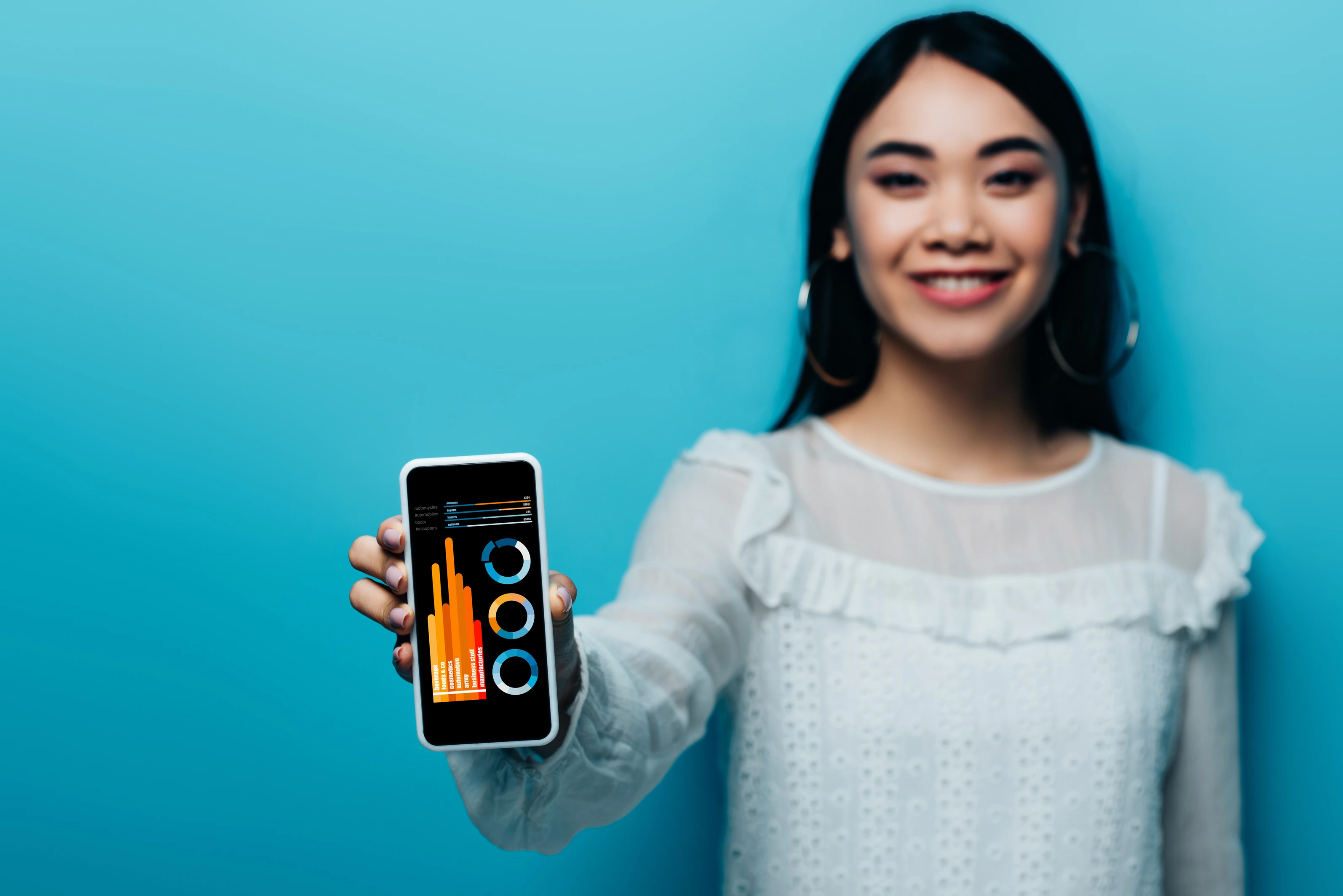 Smiling woman shows smartphone with app analytics—hero for a guide to validate app ideas via market research and MVP testing.