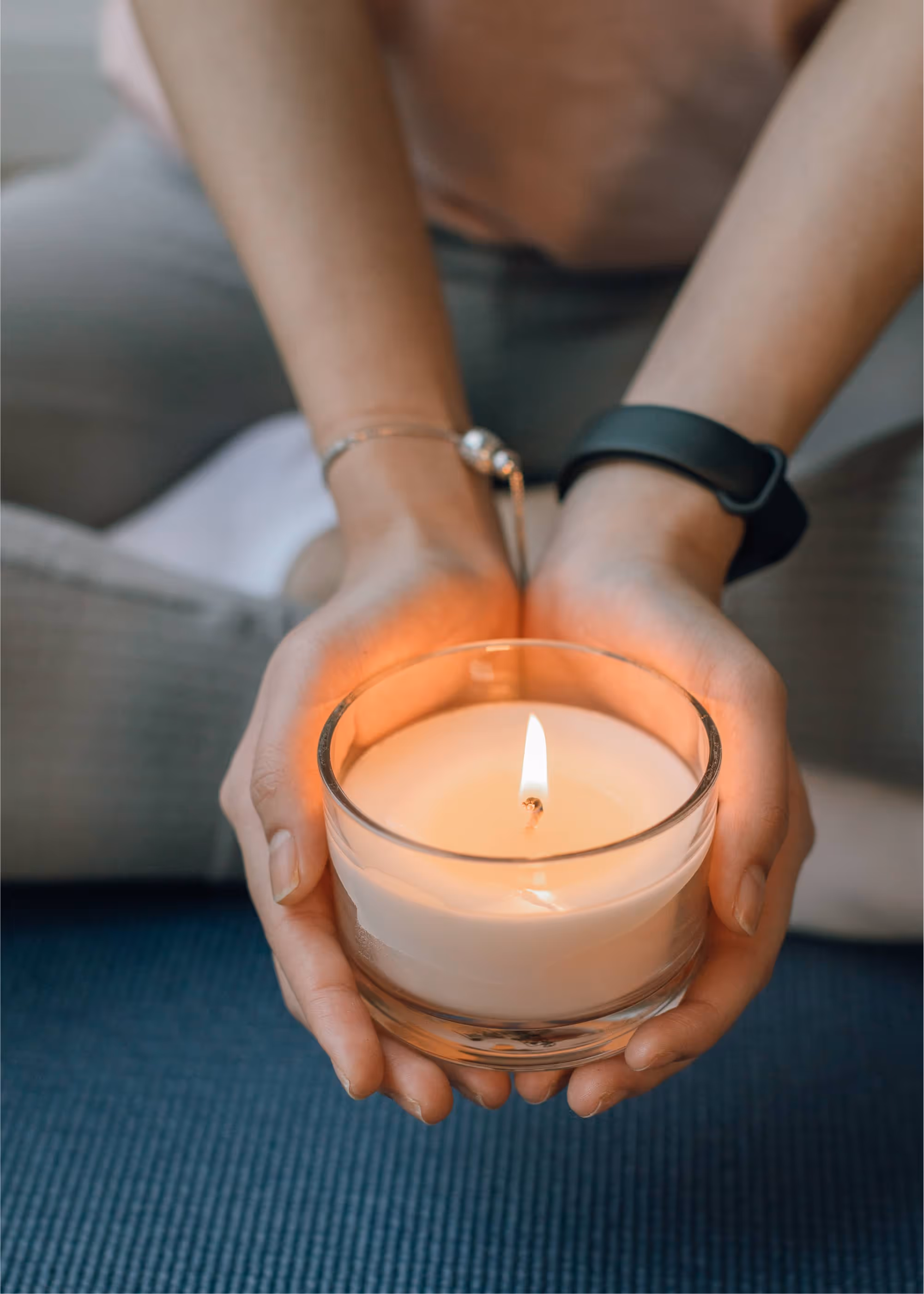Hands holding a lit candle, a simple tool to change mental conditions and improve focus.