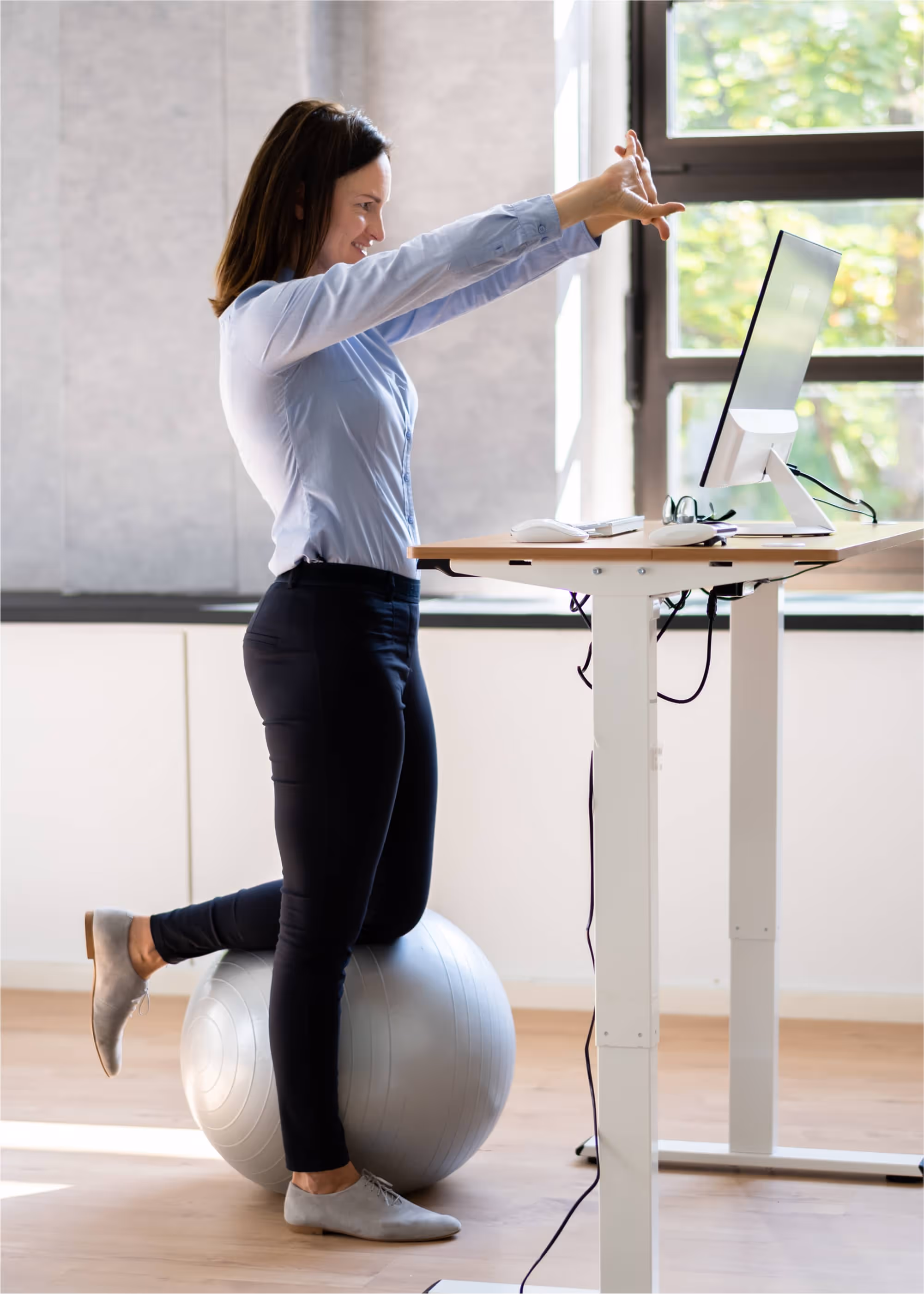 Employee using a micro-movement at her standing desk to change her physical conditions and boost energy.