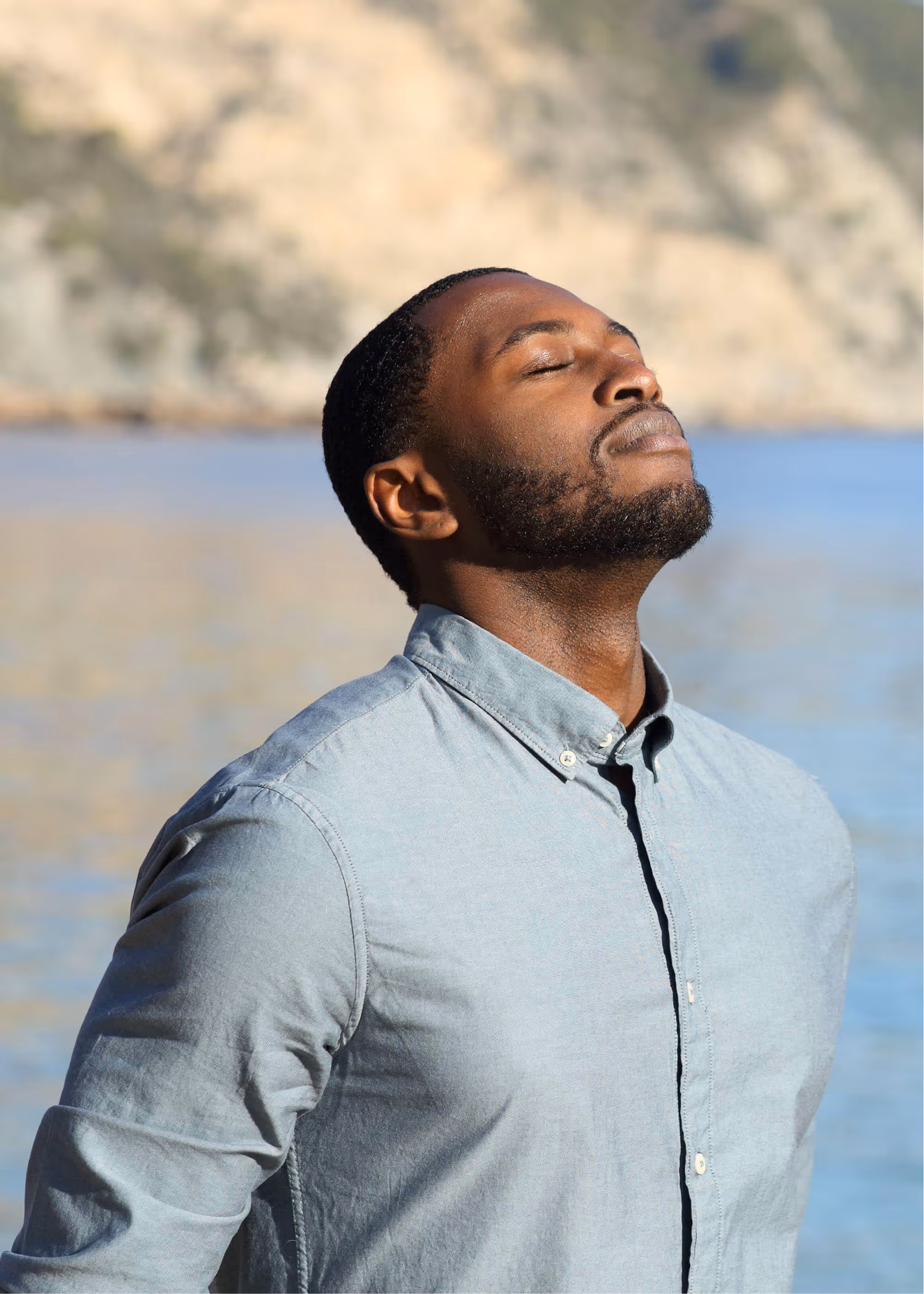 Man taking a mindful reset by the water to change his mental state and improve performance.
