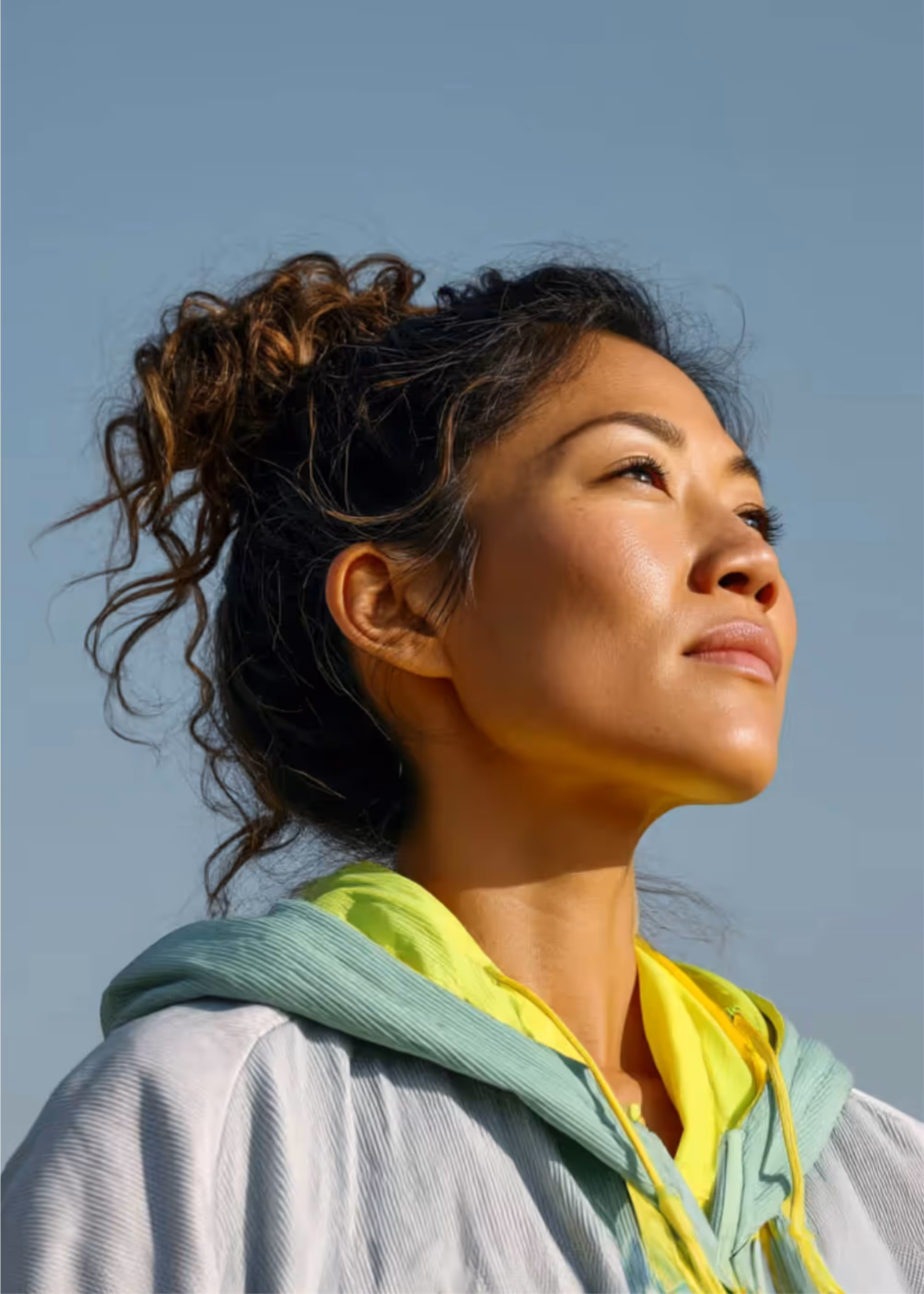 Woman looking hopefully towards the sky, reflecting the mental clarity from a better work culture.