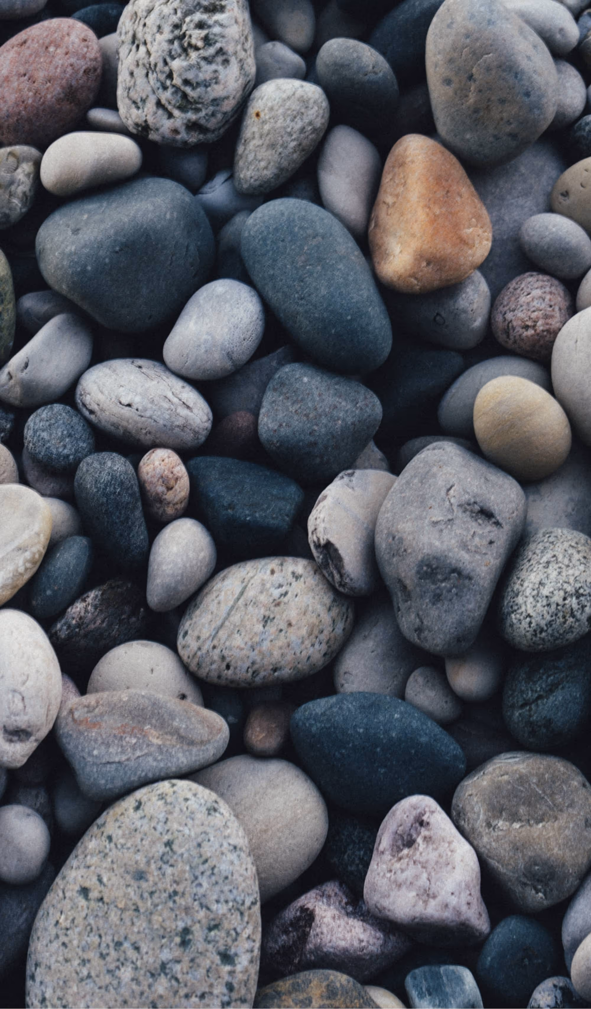 Close-up view of smooth, multicolored river stones creating a natural textured surface