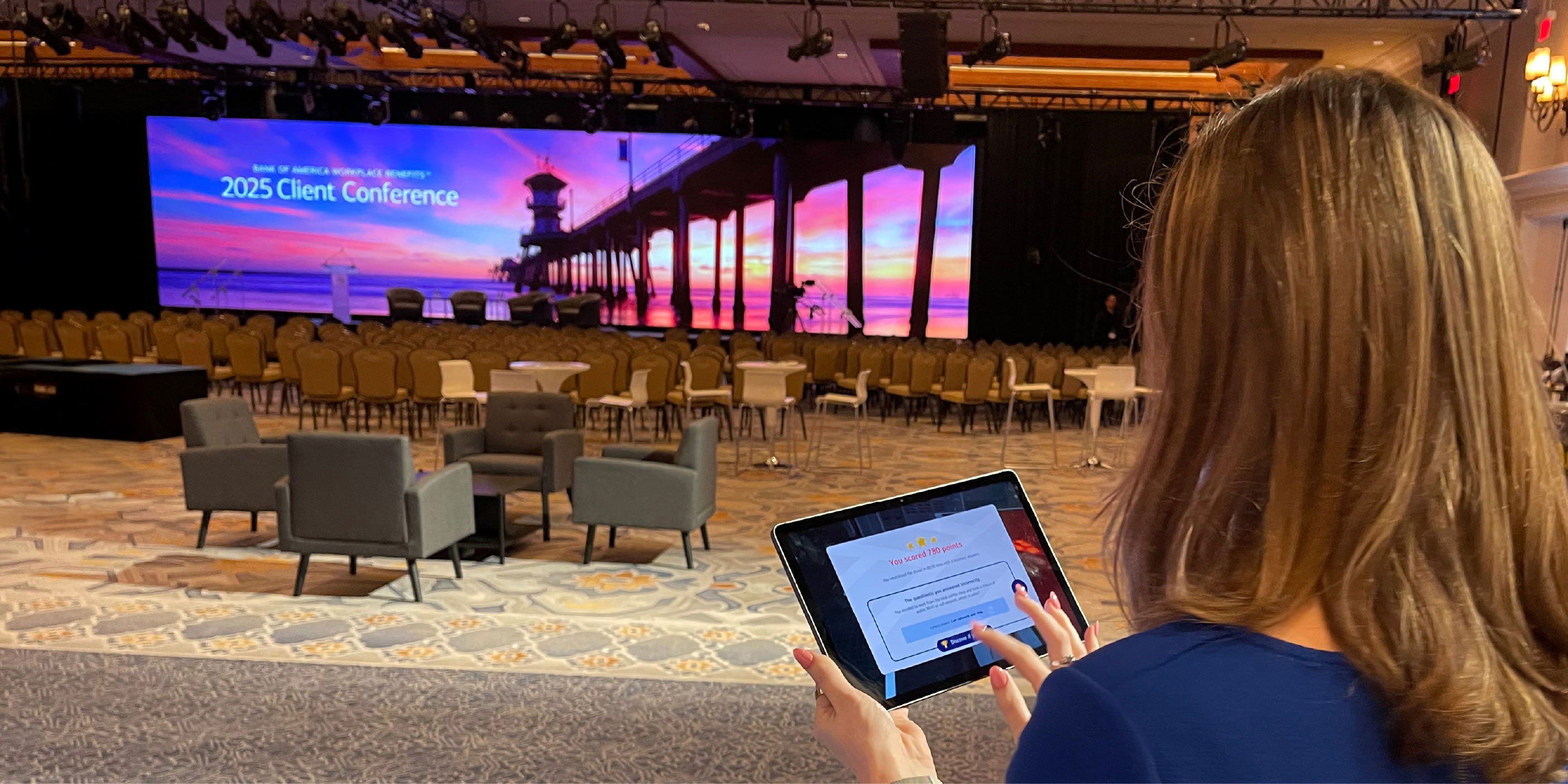 Photo of a blonde woman using a tablet in a conference room at Bank of America Workplace Benefits™ Client Conference