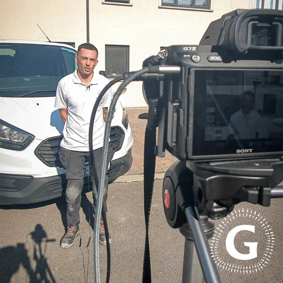 Grianan Media filming an interview with a client standing in front of a branded work van