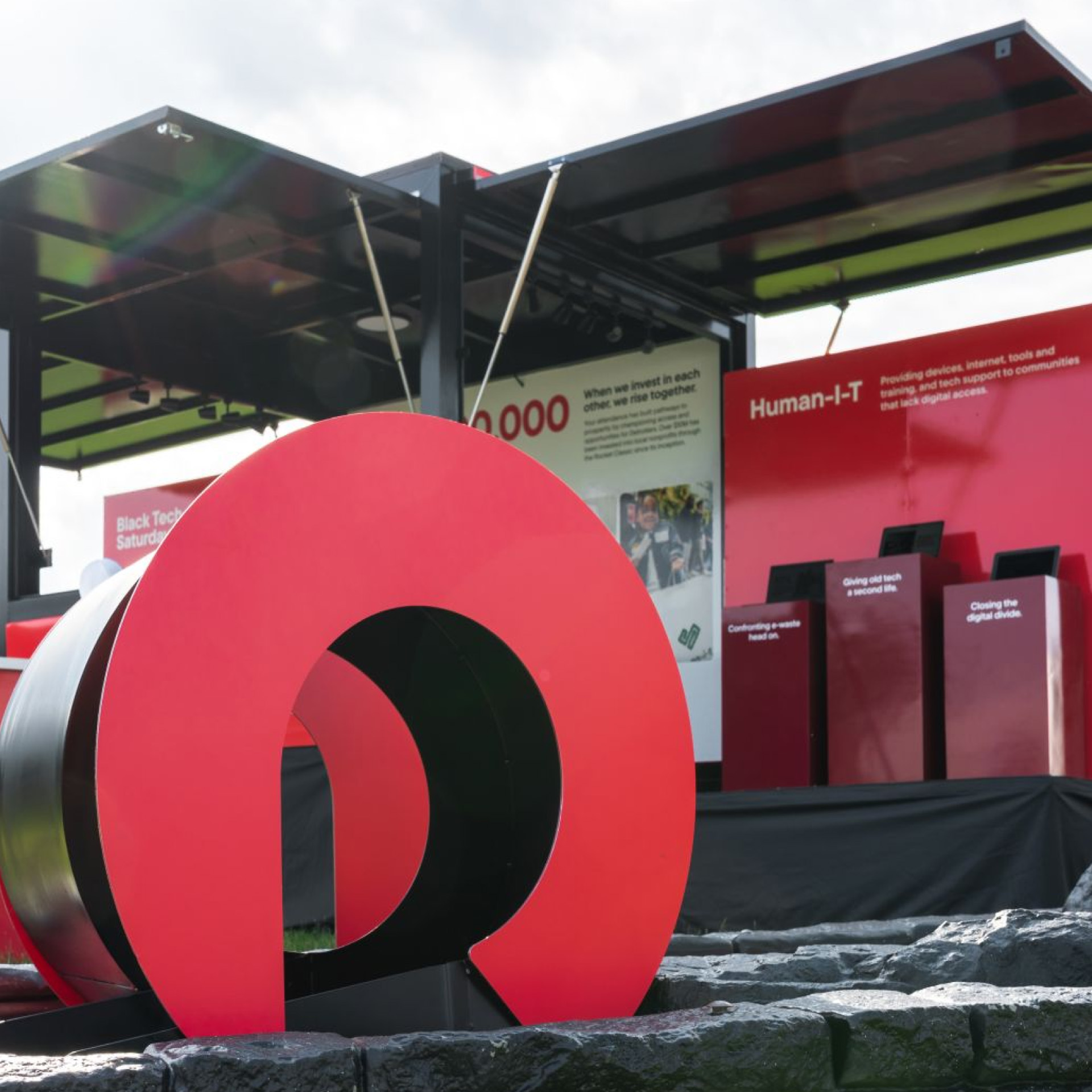 A large red Rocket Classic logo sculpture sits in front of a promotional booth showcasing community initiatives like Black Tech Saturdays and Human-I-T.