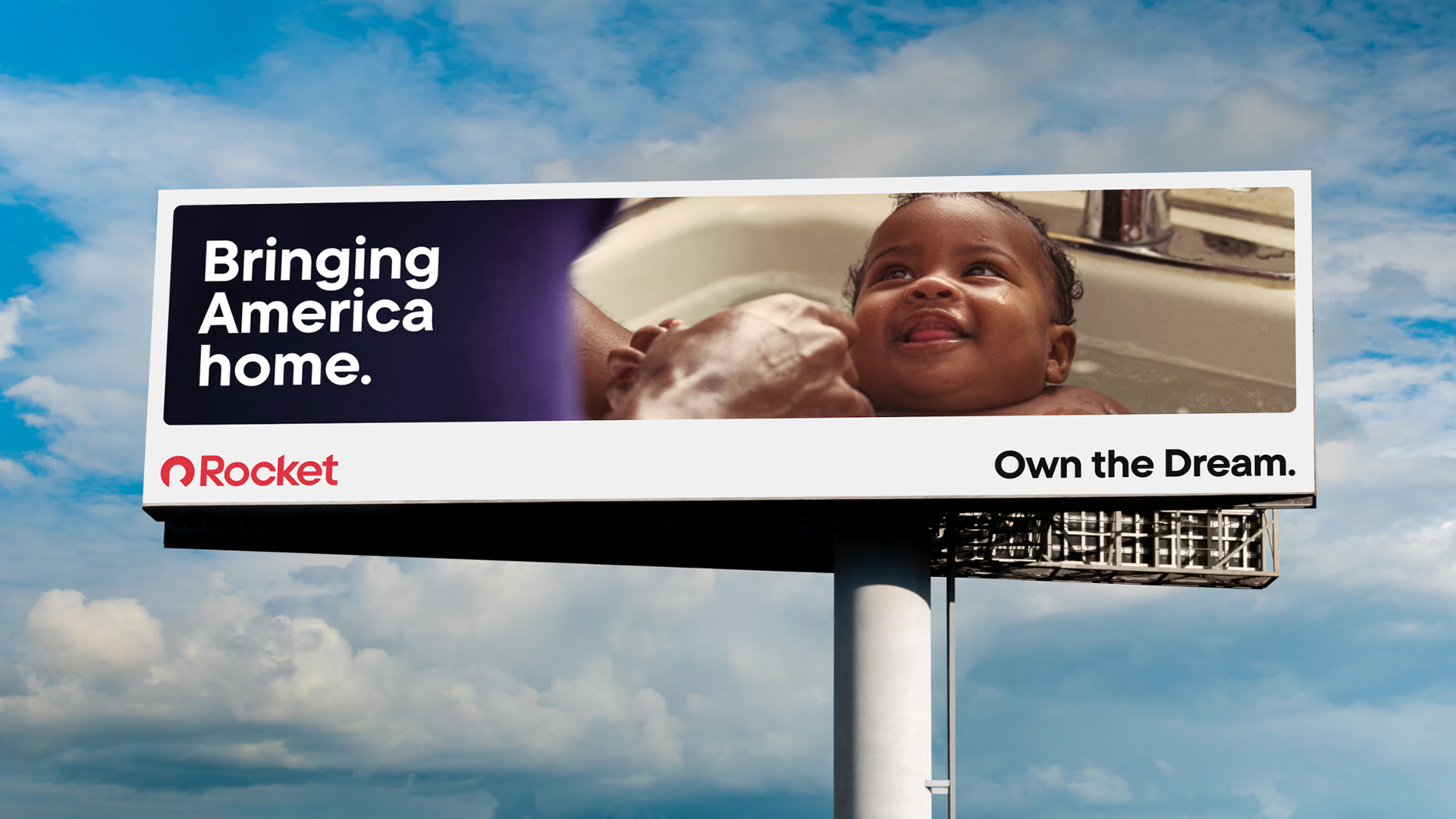 Billboard with a smiling baby being bathed. Text reads: "Bringing America home. Rocket. Own the Dream."