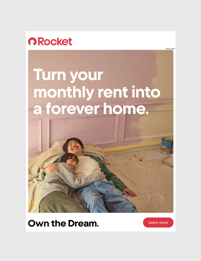 Ad showing a happy couple lying on a floor being painted. Text: "Turn your monthly rent into a forever home. Rocket. Own the Dream."