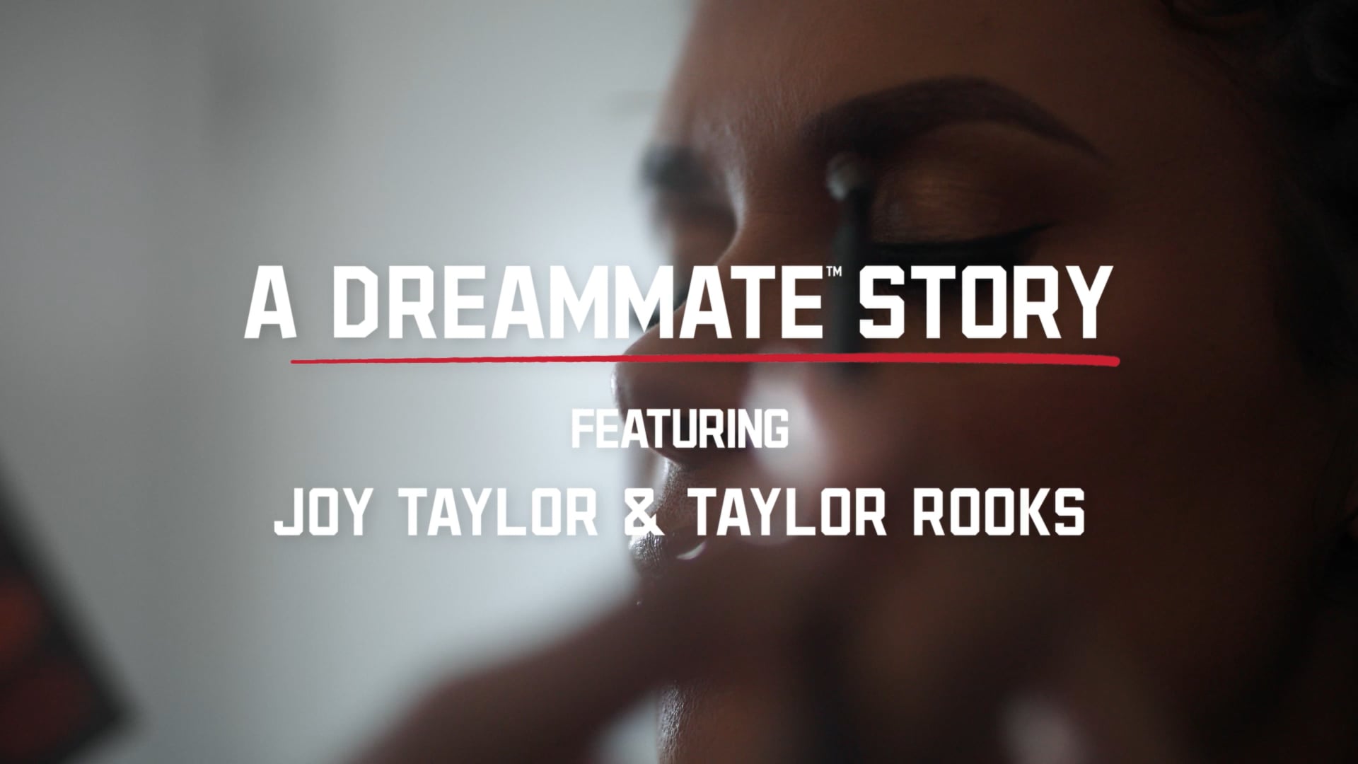 Close-up of a woman getting her makeup done, overlaid with text: “A Dreammate Story featuring Joy Taylor & Taylor Rooks.”