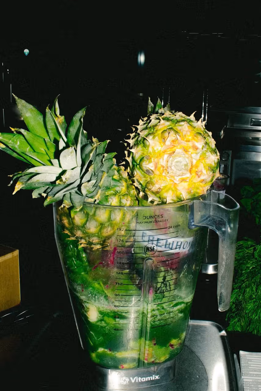 Erewhon branded Vitamix blender filled with pineapple and green ingredients being prepared for the Travis Scott Storm Smoothie collaboration