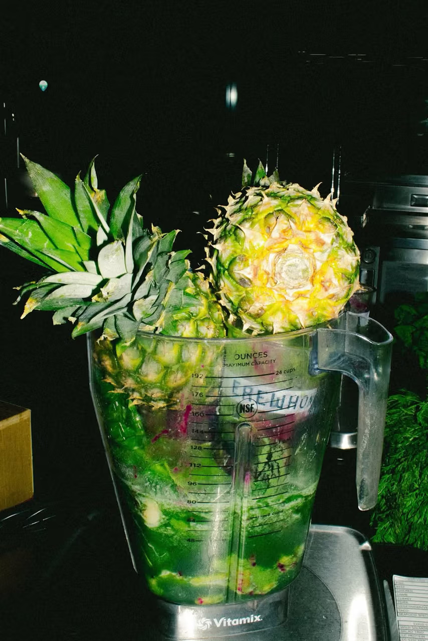 Erewhon branded Vitamix blender filled with pineapple and green ingredients being prepared for the Travis Scott Storm Smoothie collaboration