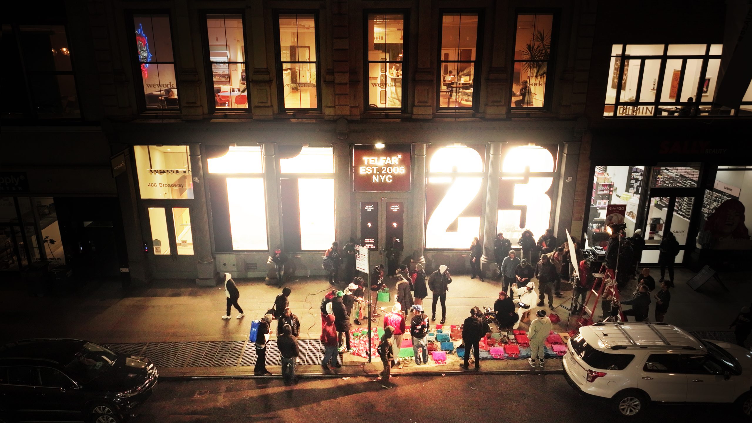 Crowd gathered outside the Telfar flagship store at 408 Broadway in New York City at night, with the illuminated storefront displaying "Telfar Est. 2005 NYC”
