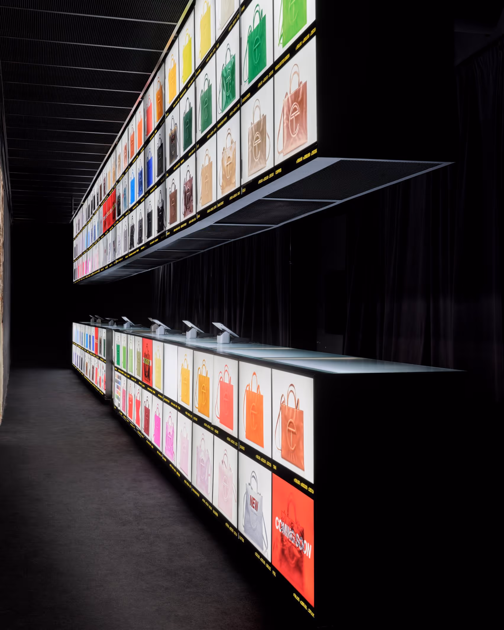 Telfar Bag Bar dark room interior with floor-to-ceiling and overhead backlit displays showing the full Shopping Bag archive across all colorways and sizes
