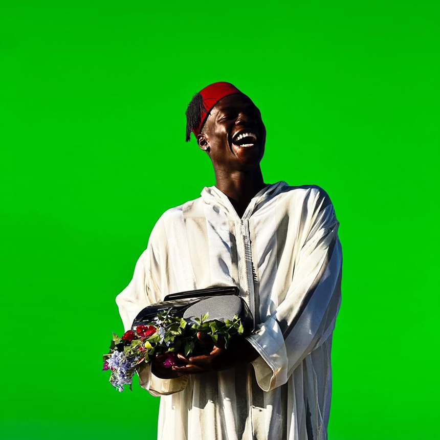 lwegav happy mauritanian customer with green background and local heritage clothing 