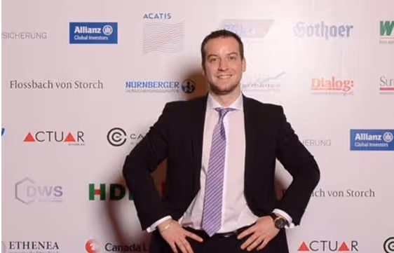 Ein Mann mit den Händen in den Hüften, steht vor einer Wand