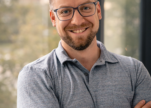 Lachender Mann mit verschränkten Armen