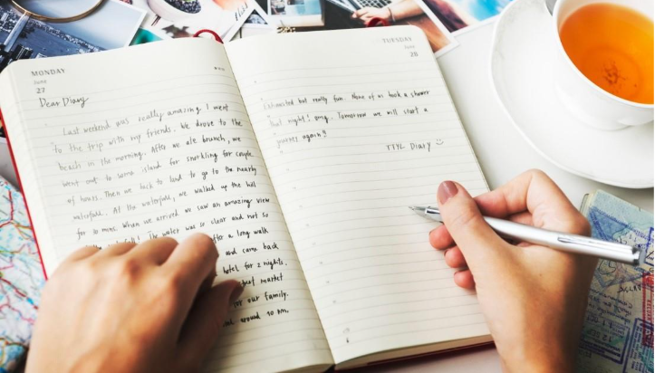 Right hand writing in a diary with a pen.